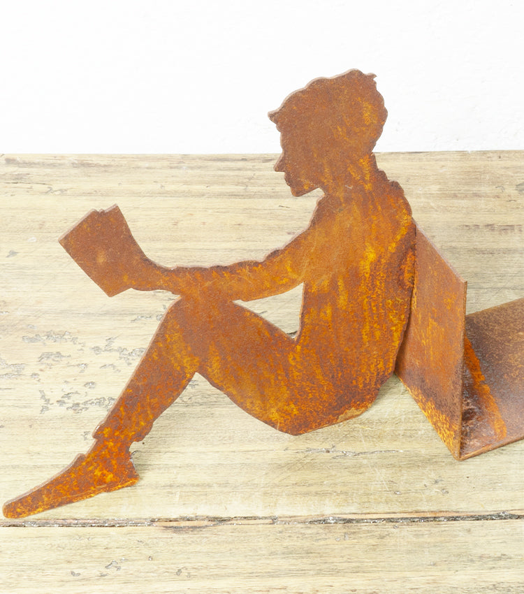 "Uomo Ferma-Libri che sta Leggendo" in corten