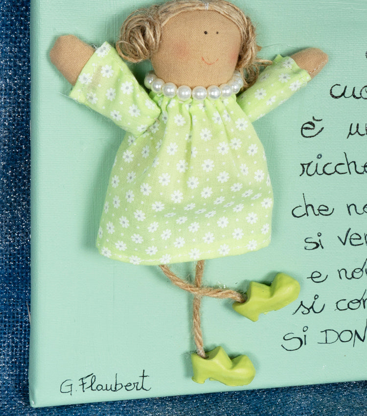 Quadro in tela con bambola e un aforisma di Gustave Flaubert