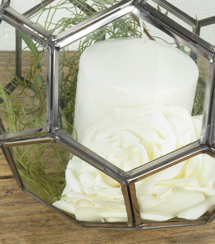 Porta-candela in vetro e metallo con candela, fiore e piante