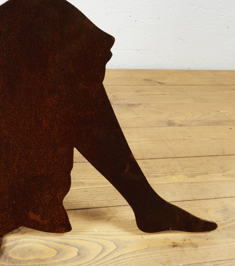 Donna seduta che sta leggendo in corten