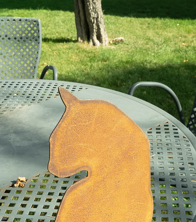 Gatto seduto con la testa girata in corten