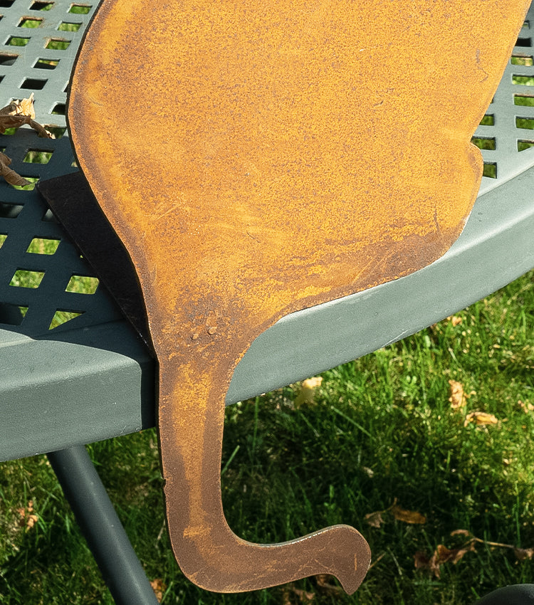 Gatto seduto con la testa girata in corten