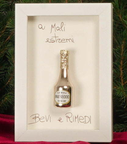 Cornice in legno "a Mali estremi Bevi e Rimedi" con una "Bottiglia di Prosecco Natalizia" in metallo