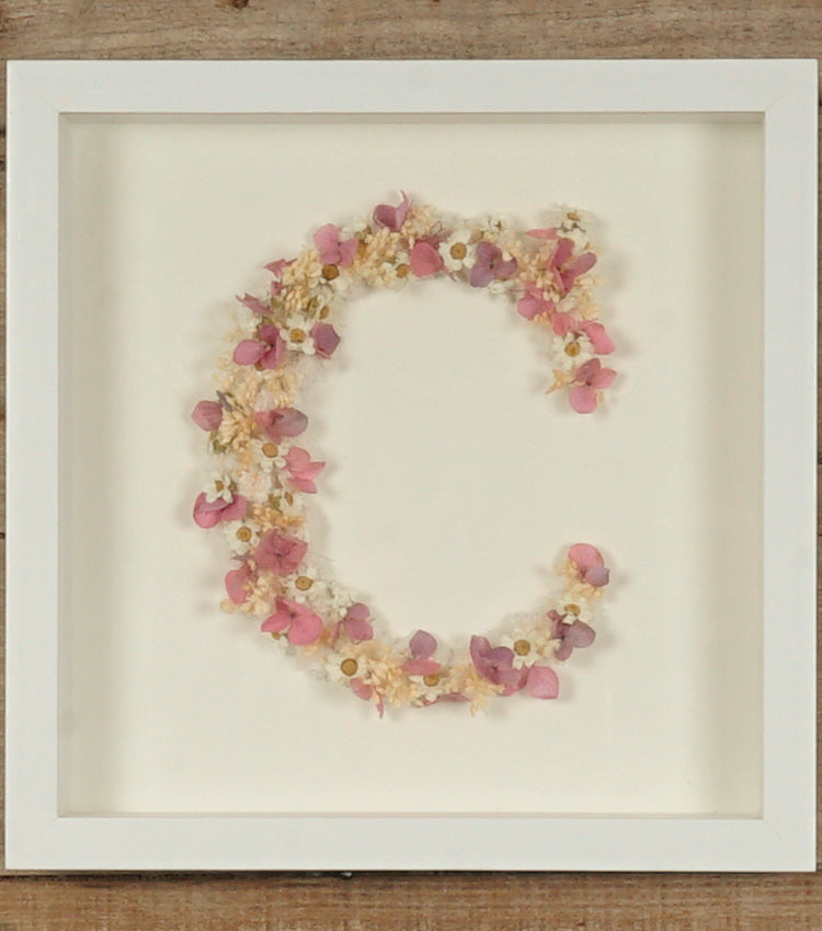 Cornice in legno con una lettera C in fiori essiccati